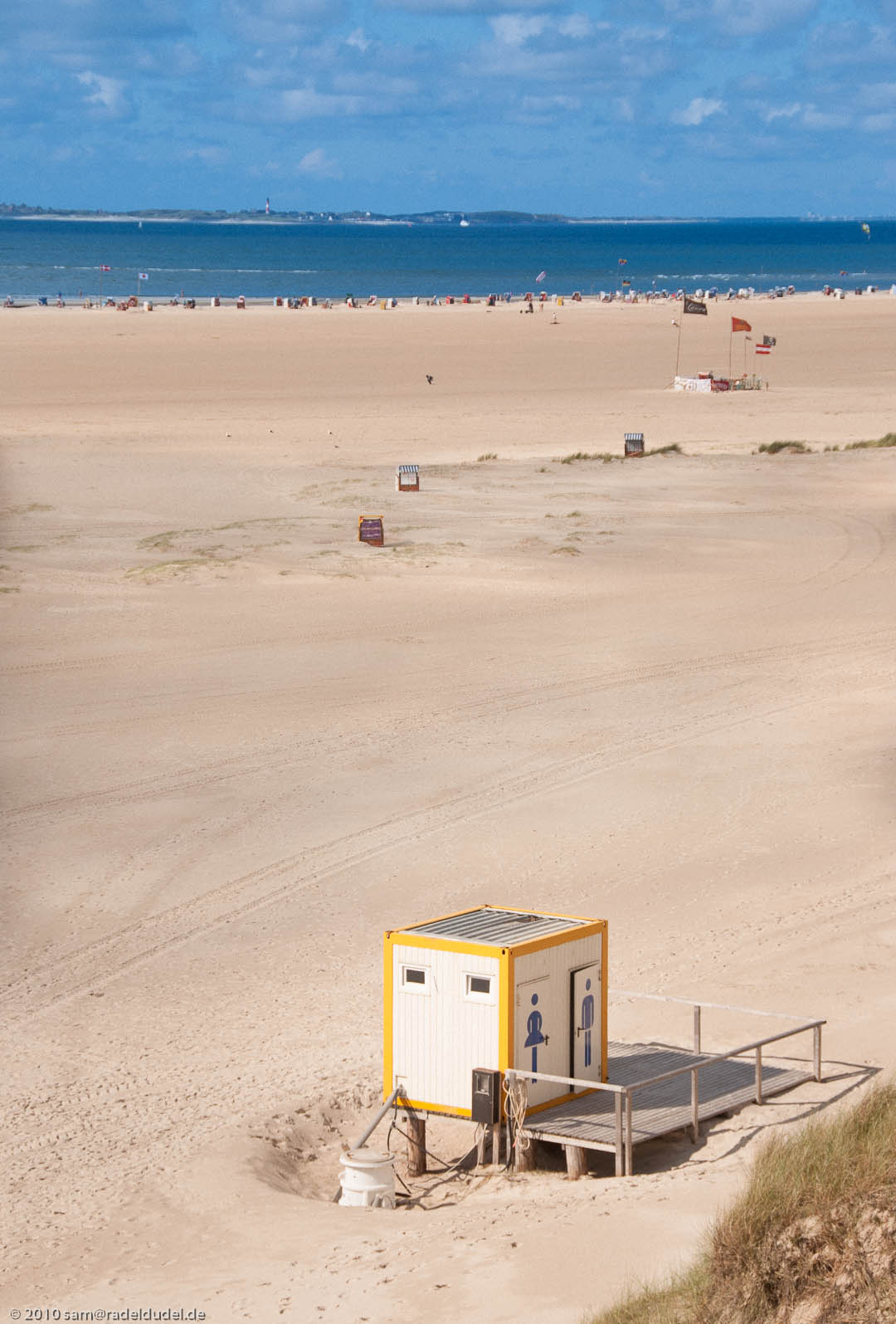 Toilettenhäuschen am Strand in Norddorf, Sylt im Hintergrund